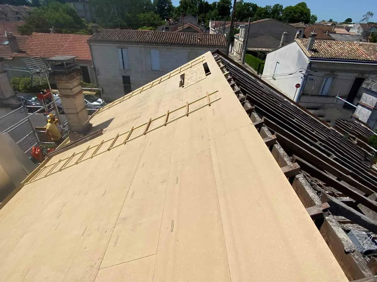Panneaux isolants posés sur la charpente en technique sarking, avec échelle de couvreur
